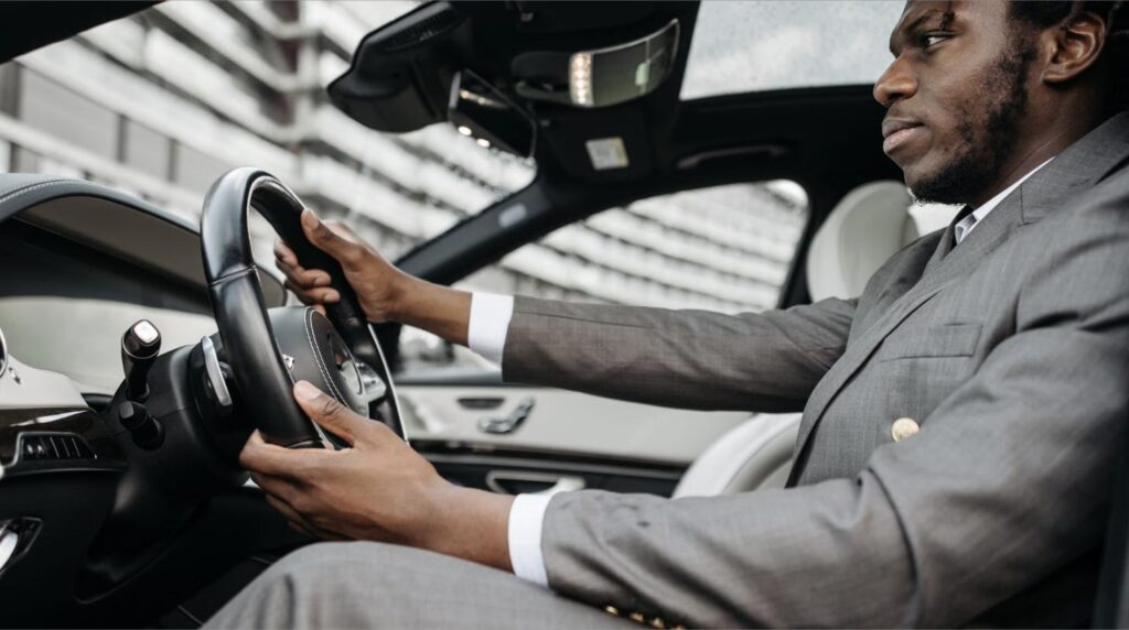 Man in a suit driving a self-drive luxury rental car in Vietnam